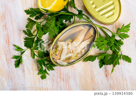 Tasty sea natural navajas in open tin can with lemon and greens 139914380