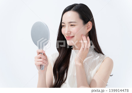 手鏡を見て肌のチェックをする女性 手鏡を見て肌のチェックをする女性 139914478