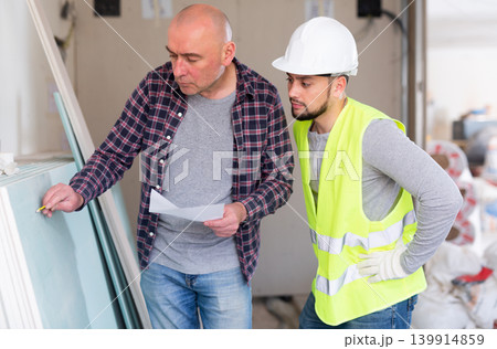 Construction manager discussing work with builder 139914859