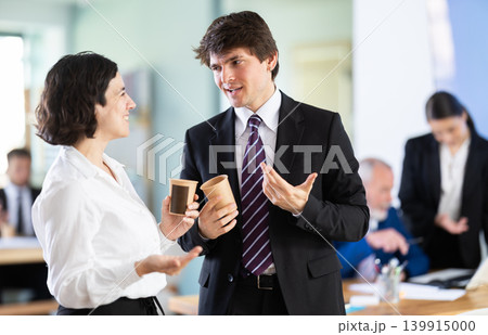 Man and a woman with hot drinks at work Man and a woman with hot drinks at work 139915000