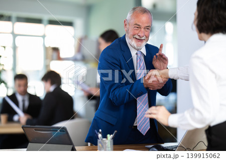 Polite mature man bank manager offering to shake hand with young woman client at office space Polite mature man bank manager offering to shake hand with young woman client at office space 139915062