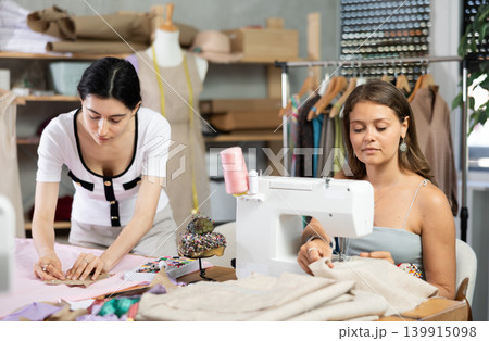 Female dressmakers sewing clothes in the workshop Female dressmakers sewing clothes in the workshop 139915098