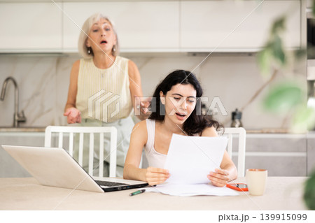 Elderly woman quarrels with young woman working at laptop Elderly woman quarrels with young woman working at laptop 139915099