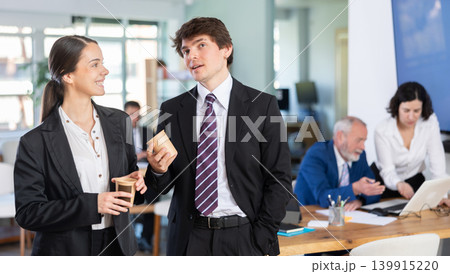 Man and a woman with hot drinks at work 139915220