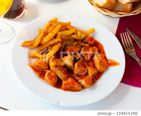 Fried pork meat with potato and tomato sauce on table 139915280