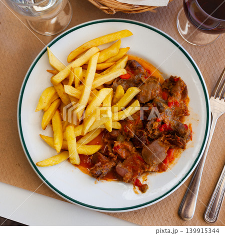 Stewed chicken gizzards in gravy with french fries Stewed chicken gizzards in gravy with french fries 139915344