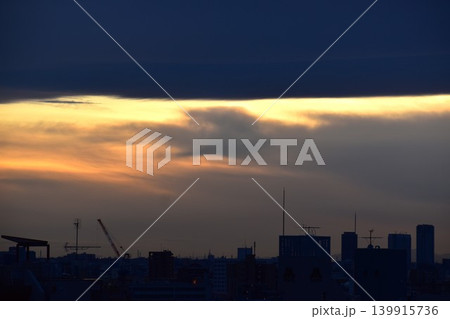 覆いかぶさる大きな雲の隙間からの夕焼け 覆いかぶさる大きな雲の隙間からの夕焼け 139915736