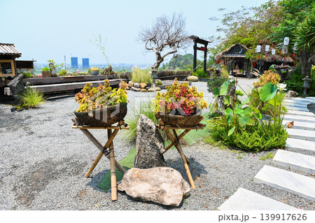 Beautiful zen garden with colorful flowers in wicker baskets on bamboo stands and stone path at a temple in Vietnam Beautiful zen garden with colorful flowers in wicker baskets on bamboo stands and stone path at a temple in Vietnam 139917626