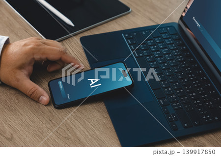 Hand using smartphone with AI interface beside laptop and tablet on office desk, suitable for password security, privacy protection, artificial intelligence authentication, and data protection 139917850