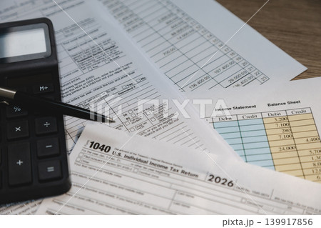 Income statement, tax paperwork, and calculator arranged for financial review, accounting preparation, bookkeeping process, and expense reporting workflow. Income statement, tax paperwork, and calculator arranged for financial review, accounting preparation, bookkeeping process, and expense reporting workflow. 139917856