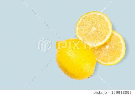 Whole lemon with two sliced pieces on a flat surface 139918095