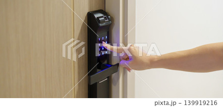 Hand press PIN number for smart digital door lock while open or close the door at home or apartment. NFC Technology, Fingerprint scan, keycard, smartphone and contactless lifestyle concepts Hand press PIN number for smart digital door lock while open or close the door at home or apartment. NFC Technology, Fingerprint scan, keycard, smartphone and contactless lifestyle concepts 139919216