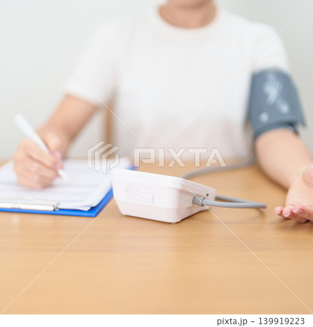 woman checking Blood pressure by Blood pressure monitor with Cuff. Systolic, SYS, Diastolic, DIA, Pulse, Hypertension, Hypotension, Heart rate, Cardiovascular Disease and May World hypertension day woman checking Blood pressure by Blood pressure monitor with Cuff. Systolic, SYS, Diastolic, DIA, Pulse, Hypertension, Hypotension, Heart rate, Cardiovascular Disease and May World hypertension day 139919223