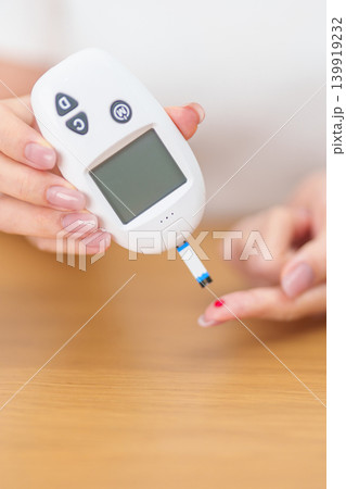 Hand checking Diabetes or Blood glucose self testing by digital blood glucose meter with lancet pen. high blood sugar level, World Diabetes Day, Glycemia, Hypoglycemia, Hyperglycemia and insulin Hand checking Diabetes or Blood glucose self testing by digital blood glucose meter with lancet pen. high blood sugar level, World Diabetes Day, Glycemia, Hypoglycemia, Hyperglycemia and insulin 139919232
