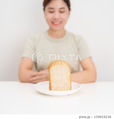 Happy smiling woman with whole wheat bread. Weight loss management, Dieting, Healthy eating, Calorie control, Fitness food, High fiber, Wellness, Lifestyle, Metabolism and Glycemic Index Happy smiling woman with whole wheat bread. Weight loss management, Dieting, Healthy eating, Calorie control, Fitness food, High fiber, Wellness, Lifestyle, Metabolism and Glycemic Index 139919238