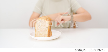 Happy smiling woman with whole wheat bread and time watch. concept of intermittent fasting, IF, meal timing, and choosing healthy carbohydrates for a balanced diet and weight loss management 139919249