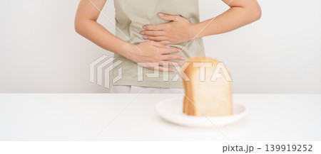 Gluten intolerance, Gluten free and celiac disease or Wheat allergy. woman with wheat bread and having abdominal pain after eat gluten. stomach ache, Nausea, Bloating, Gas, Diarrhea and Skin rash 139919252