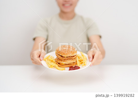 happy woman eating Juicy beef burger with melted cheddar cheese, potato chips. Unhealthy, High calorie, Fast food craving, Obesity, diet, weight loss, junk food and lifestyle happy woman eating Juicy beef burger with melted cheddar cheese, potato chips. Unhealthy, High calorie, Fast food craving, Obesity, diet, weight loss, junk food and lifestyle 139919282