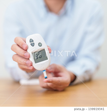 Hand checking Diabetes or Blood glucose self testing by digital blood glucose meter with lancet pen. high blood sugar level, World Diabetes Day, Glycemia, Hypoglycemia, Hyperglycemia and insulin 139919341