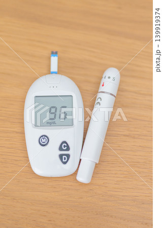 digital blood glucose meter with lancet pen on table. Diabetes checking or Blood glucose self testing, blood sugar level, World Diabetes Day, Glycemia, Hypoglycemia, Hyperglycemia and insulin digital blood glucose meter with lancet pen on table. Diabetes checking or Blood glucose self testing, blood sugar level, World Diabetes Day, Glycemia, Hypoglycemia, Hyperglycemia and insulin 139919374