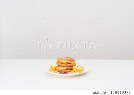 juicy beef burger with melted cheddar cheese, potato chips on table. Unhealthy, High calorie, Fast food craving, Obesity, diet, weight loss, junk food and lifestyle 139919375