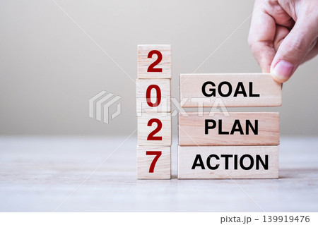 hand holding wooden block with text 2027 GOAL, PLAN and ACTION on table background. Resolution, strategy, solution, goal, business and New Year holiday concepts 139919476