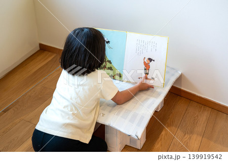 絵本を読む子どもの後ろ姿と手作り机のある暮らし 絵本を読む子どもの後ろ姿と手作り机のある暮らし 139919542