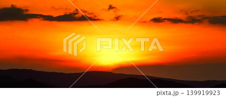 西の空にゆっくりドラマチックに沈むオレンジ色の太陽 139919923