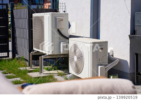 Outdoor heat pump units installed near house exterior wall 139920519