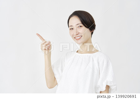 左側を指差すミドルエイジ女性　白背景 139920691