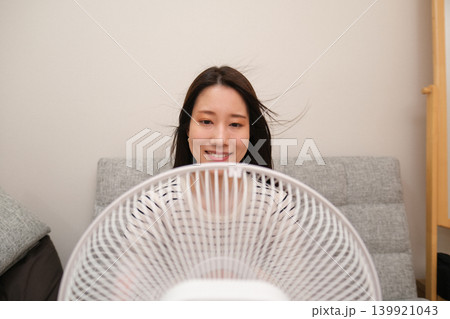 家の中で扇風機で涼む女性 139921043
