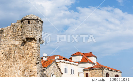 Budva Citadel view, a historic stone fortress tower rises beside traditional houses 139921081