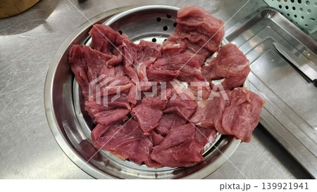 Raw Sliced Beef Preparation in Metal Bowl on Kitchen Counter Raw Sliced Beef Preparation in Metal Bowl on Kitchen Counter 139921941