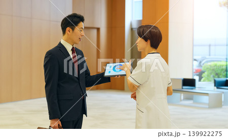 ビジネスパーソンと会話する女性医療スタッフ ビジネスパーソンと会話する女性医療スタッフ 139922275