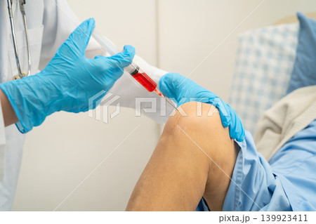 Asian doctor inject Hyaluronic acid platelet rich plasma into knee of senior woman. Asian doctor inject Hyaluronic acid platelet rich plasma into knee of senior woman. 139923411