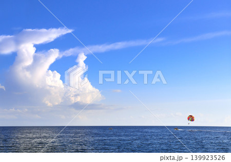 Picturesque view of sea and tourists on a parachute. Topic of summer vacation, travel, leisure and adventure for tourist. Parasailing in the sea. A popular tourist pastime with a parascending 139923526