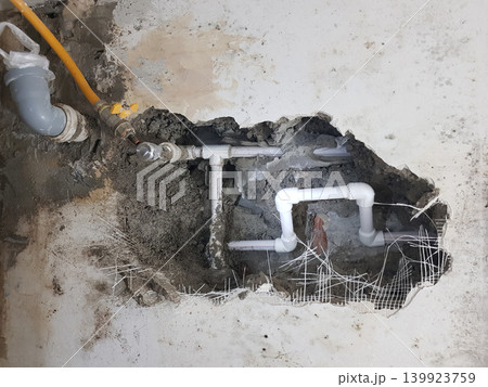Damaged wall exposing burst water pipes after flood Damaged wall exposing burst water pipes after flood 139923759