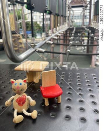 Small wooden toys arranged on a playground surface in an urban area during daylight hours Small wooden toys arranged on a playground surface in an urban area during daylight hours 139923772
