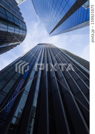 Looking up at towering corporate office buildings in city 139923875