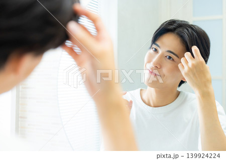 洗面所で鏡を見る男性 139924224