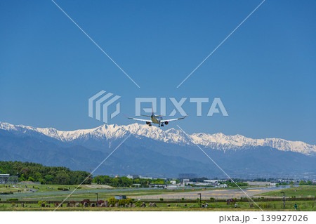 信州まつもと空港に着陸する飛行機と残雪の北アルプス連峰 139927026