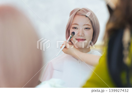 ヘアメイクしてもらうハイトーンヘアの女性 ヘアメイクしてもらうハイトーンヘアの女性 139927432