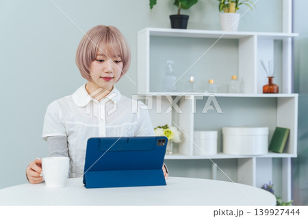 タブレットPCを見るハイトーンヘアの女性 タブレットPCを見るハイトーンヘアの女性 139927444