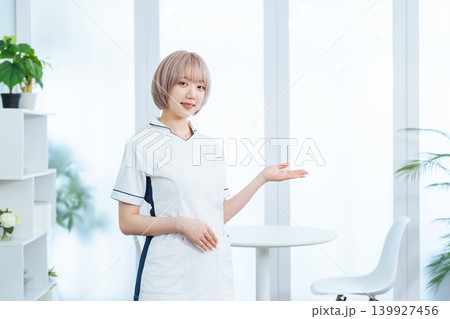 接客するハイトーンヘアの女性スタッフ 接客するハイトーンヘアの女性スタッフ 139927456