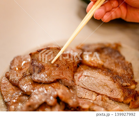 焼肉を箸でつまむ 139927992