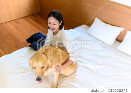 ベッドで犬とくつろぐ女性 ベッドで犬とくつろぐ女性 139928241