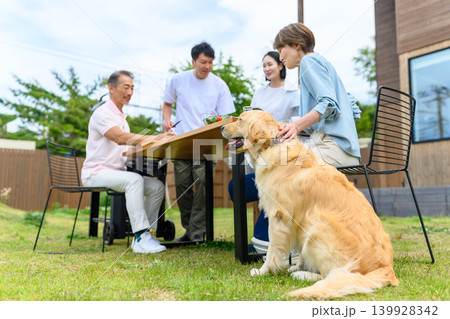 庭でバーベキューを楽しむ家族と犬 庭でバーベキューを楽しむ家族と犬 139928342