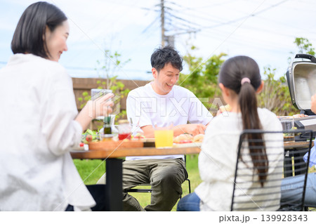屋外でバーベキューを楽しむ家族 139928343