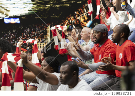 Shocked supporter celebrating high stakes betting win on mobile betting app during a live soccer match inside the stadium. Excited fan reacts to the winning odds and big payout, cheering for victory. 139928721