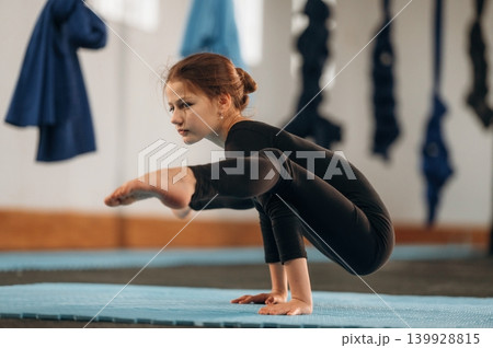 Concentration and strength conception, on the hands. Child practicing yoga on a mat in a fitness studio Concentration and strength conception, on the hands. Child practicing yoga on a mat in a fitness studio 139928815